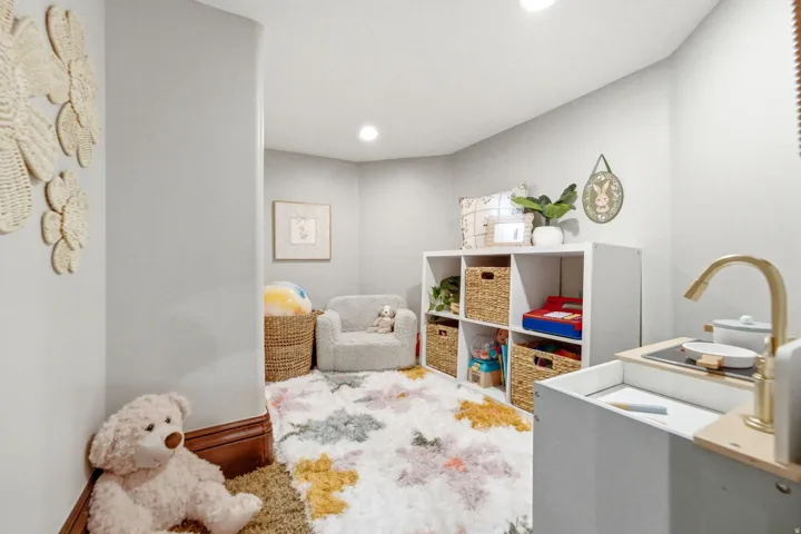 Recessed ceiling lighting, light gray wall finishes, white built-in cube storage, and dark wood-finish trim