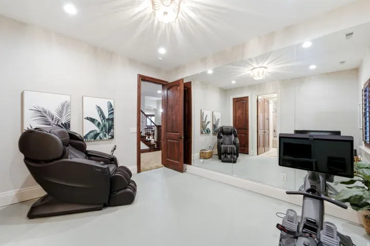 Integrated wall-to-wall mirror with recessed lighting and a decorative ceiling fixture