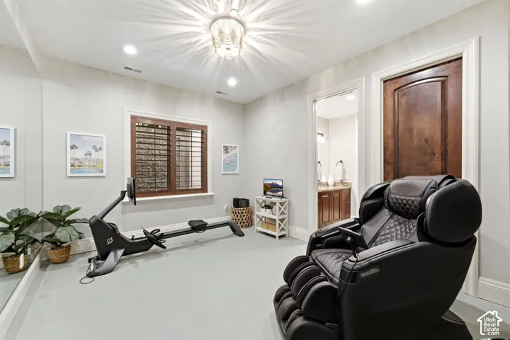Recessed lighting, wood-finish interior door, plantation shutters, full-height wall mirror, and a decorative ceiling light fixture