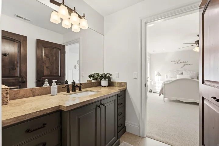 Vanity with a light-toned countertop, undermount sink, and dark cabinetry