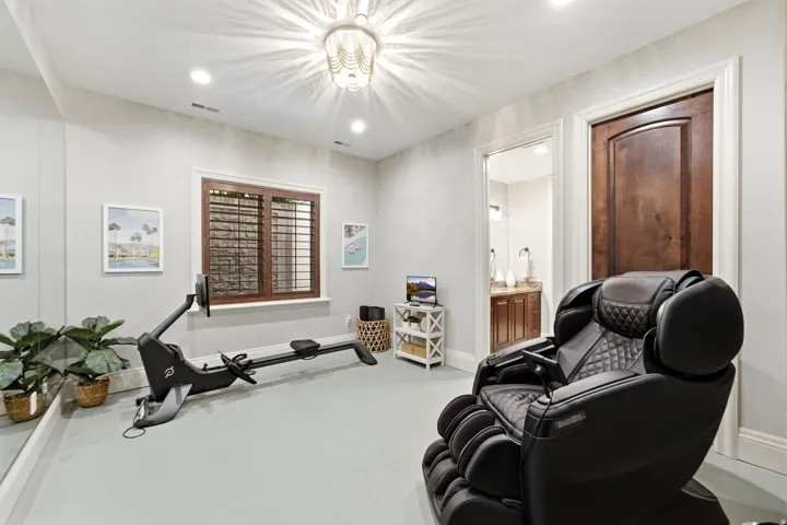 Recessed lighting, wood-finish interior door, plantation shutters, full-height wall mirror, and a decorative ceiling light fixture
