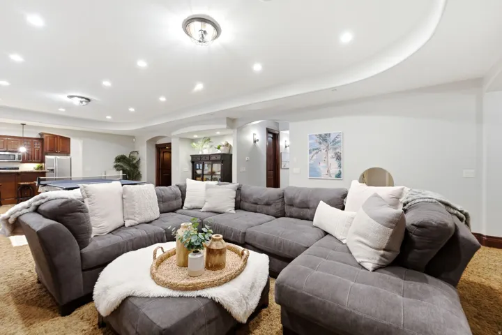 Recessed ceiling lighting, curved architectural ceiling detail, built-in shelving, wood-finish flooring, and a recessed archway