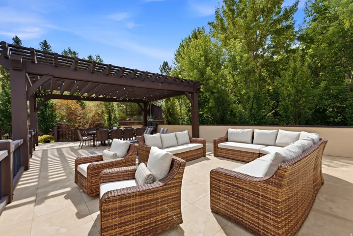 Roof Top Deck Expansive outdoor patio featuring a large pergola, hardscape flooring, and a low privacy wall