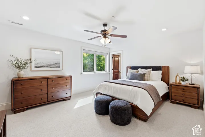 Recessed lighting, ceiling fan, carpeted flooring, window with natural light, and a wood-paneled door