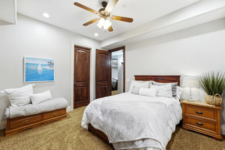 Recessed ceiling lighting, a wood-finish ceiling fan, and two paneled wood doors