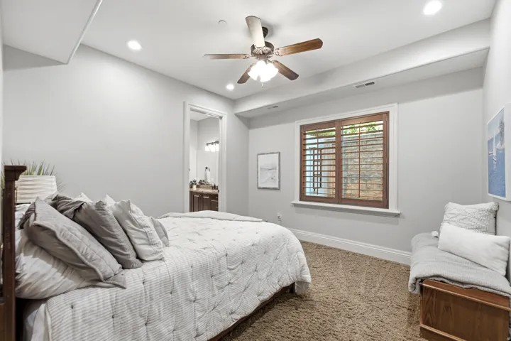 Recessed lighting illuminates the space, featuring a ceiling fan with light