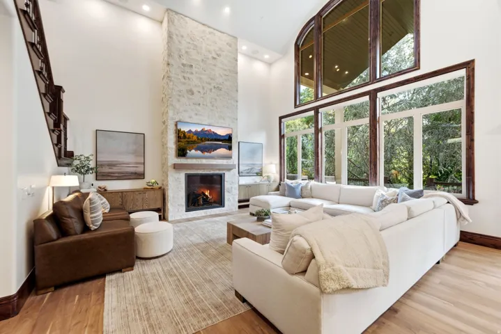 Two-story living area with a stone-clad fireplace and wood mantle