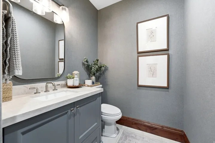 Built-in vanity with a stone countertop, undermount sink, and brushed nickel faucet