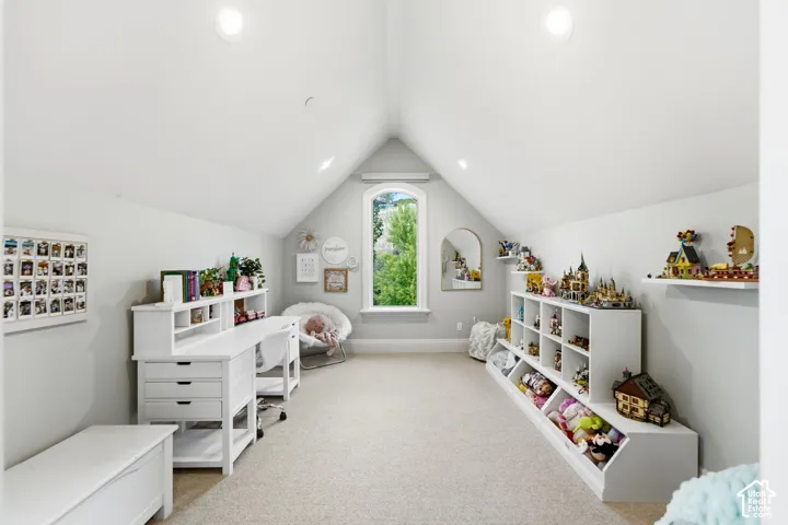Vaulted ceiling room with recessed lighting, an arched window, and built-in storage shelving units