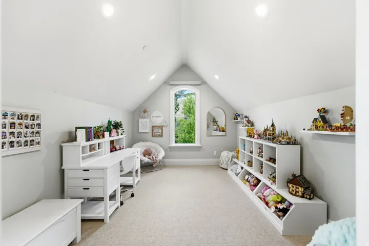 Vaulted ceiling room with recessed lighting, an arched window, and built-in storage shelving units
