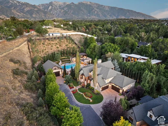 Expansive property featuring a multi-level residence, swimming pool, extensive hardscaping, mature landscaping, and an integrated garage