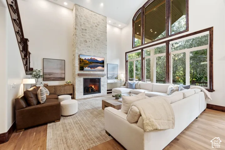 Two-story living area with a stone-clad fireplace and wood mantle