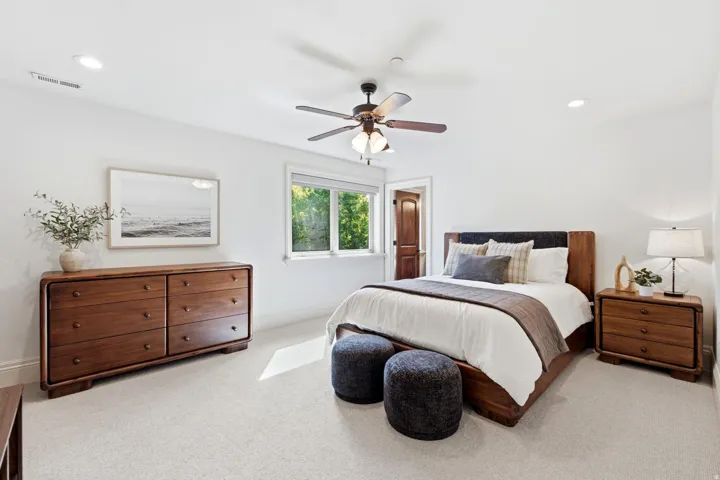 Recessed lighting, ceiling fan, carpeted flooring, window with natural light, and a wood-paneled door