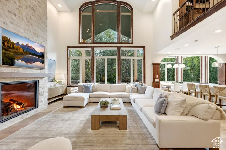 Two-story living area with a stone fireplace, wood-finish flooring, and a second-story interior balcony with wood railing