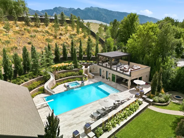 Expansive pool area featuring an in-ground pool, integrated hot tub, and diving board