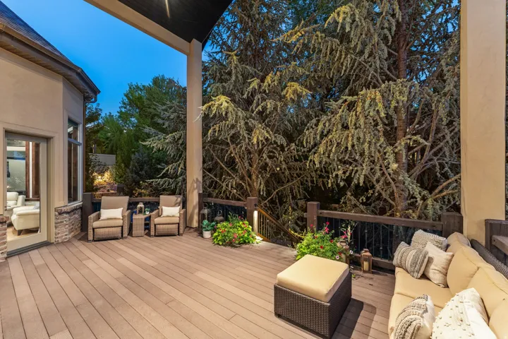Spacious outdoor deck with wood-finish flooring, dark wood railings, and integrated lighting