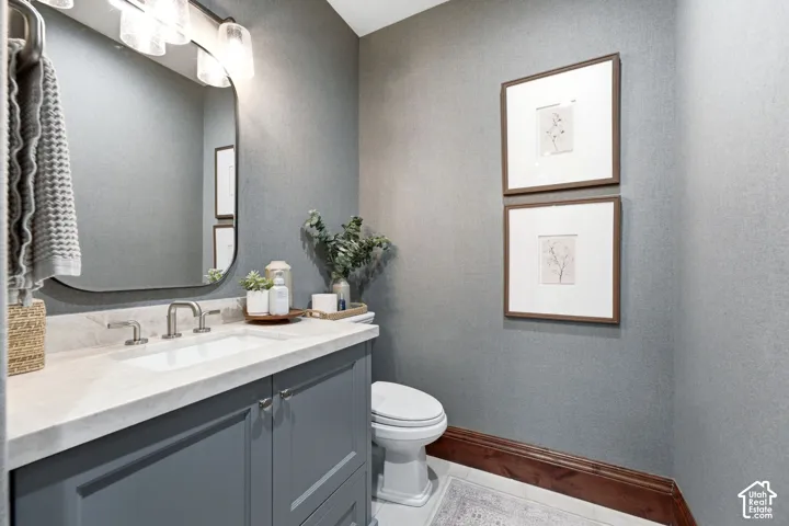 Built-in vanity with a stone countertop, undermount sink, and brushed nickel faucet