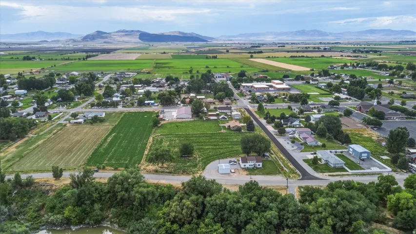 Expansive rural landscape featuring established residential areas, cultivated fields, and distant mountains