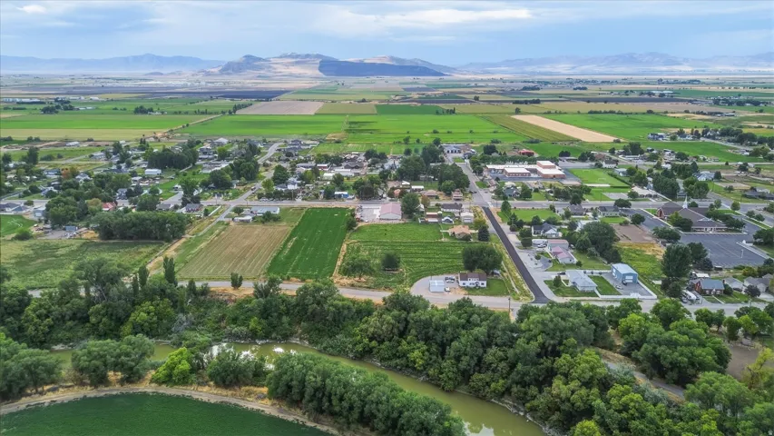 Aerial perspective showcasing a community surrounded by agricultural fields and distant mountains