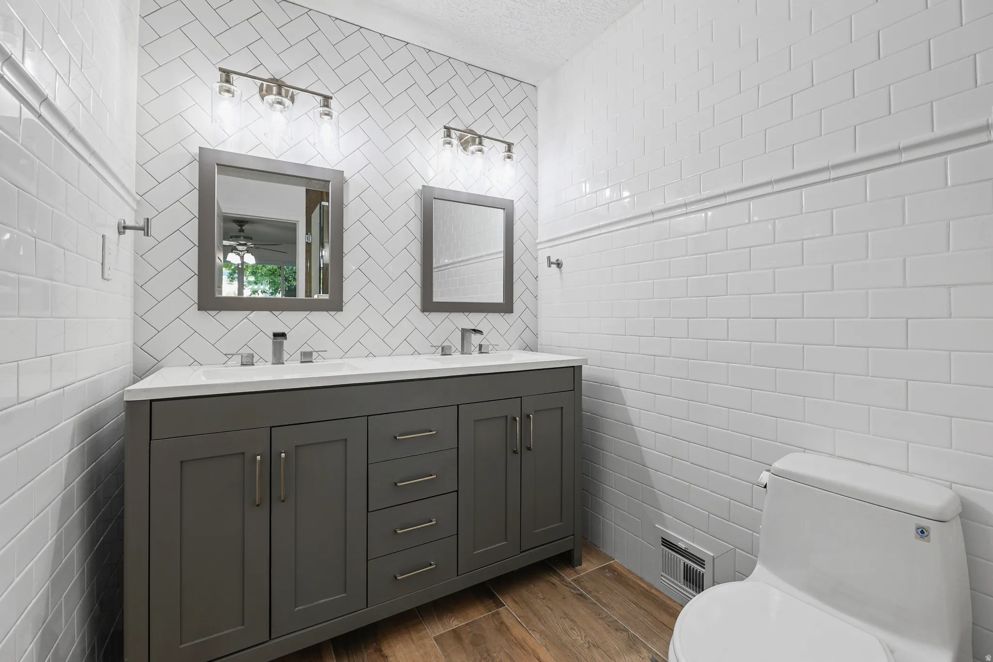 Primary Bathroom: Updated Vanity, Mirrors, & Light Fixtures Plus Double Sinks with New Subway Tile on Walls
