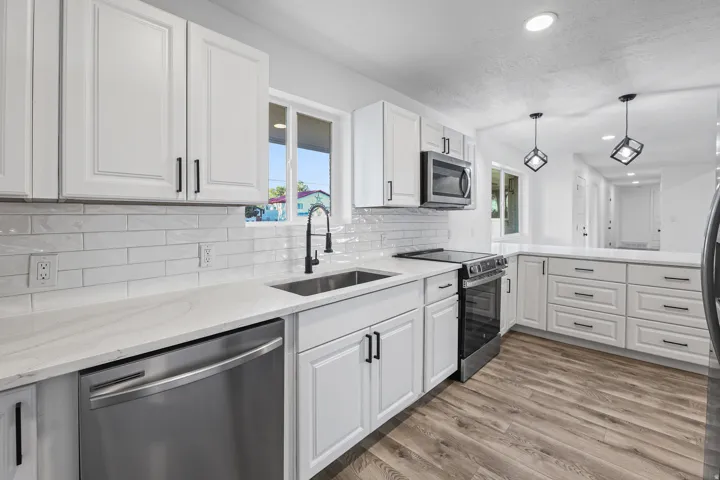 Updated White Cabinets with Quartz Countertops, a Tile Backsplash, Stainless Appliances, & Pantry