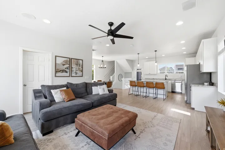 Open-concept living space featuring wood-finish flooring, recessed lighting, and a contemporary ceiling fan