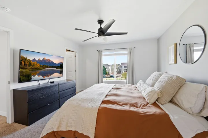 Ceiling fan with five blades, large window with natural light, and recessed lighting