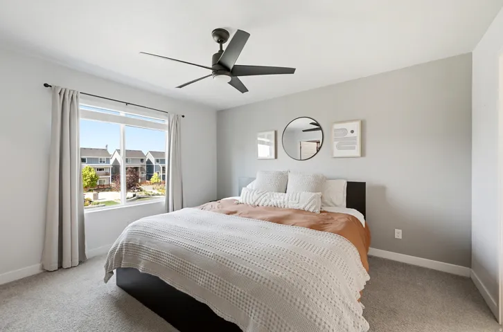 Large window with white trim, a ceiling fan with integrated lighting, and neutral wall paint