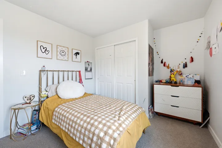 Integrated sliding closet, light-toned carpeting, and white walls