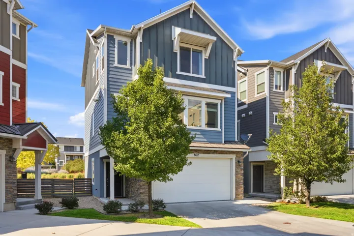 Multi-level residence featuring a two-car garage, stone accents, and varied siding