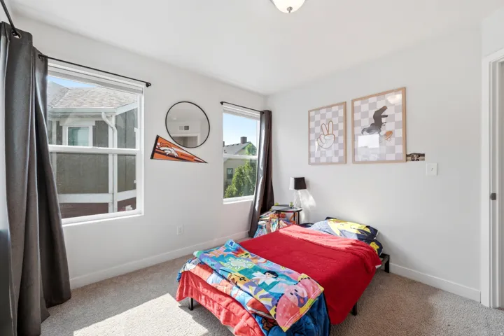 Carpeted flooring, white walls, and two windows