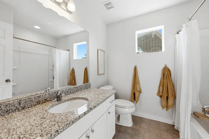 White vanity with granite-finish countertop and undermount sink