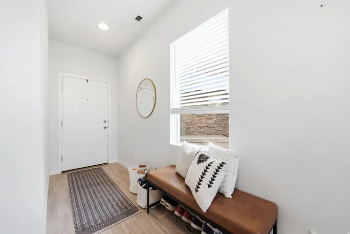 Entryway with wood-finish flooring, a white paneled door, and a recessed ceiling light