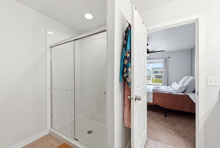 Shower enclosure with sliding glass doors and recessed lighting