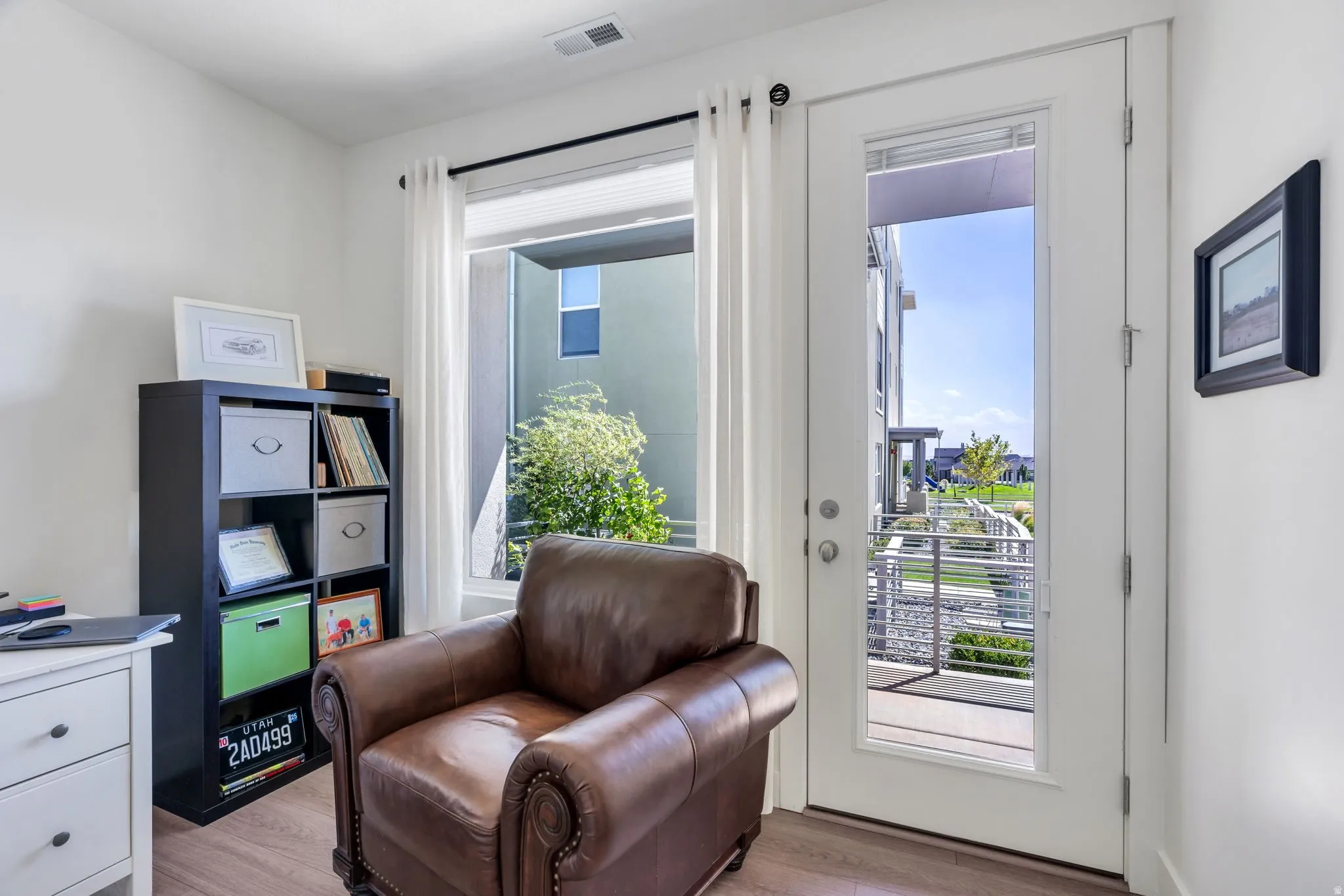 Wood-finish flooring, white walls, and a full-light door providing exterior access