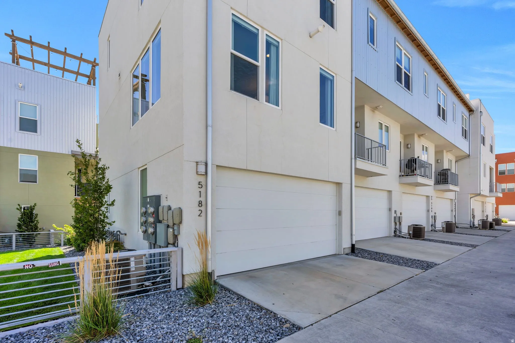 Modern multi-level exterior with vertical siding, multiple windows, and a private balcony