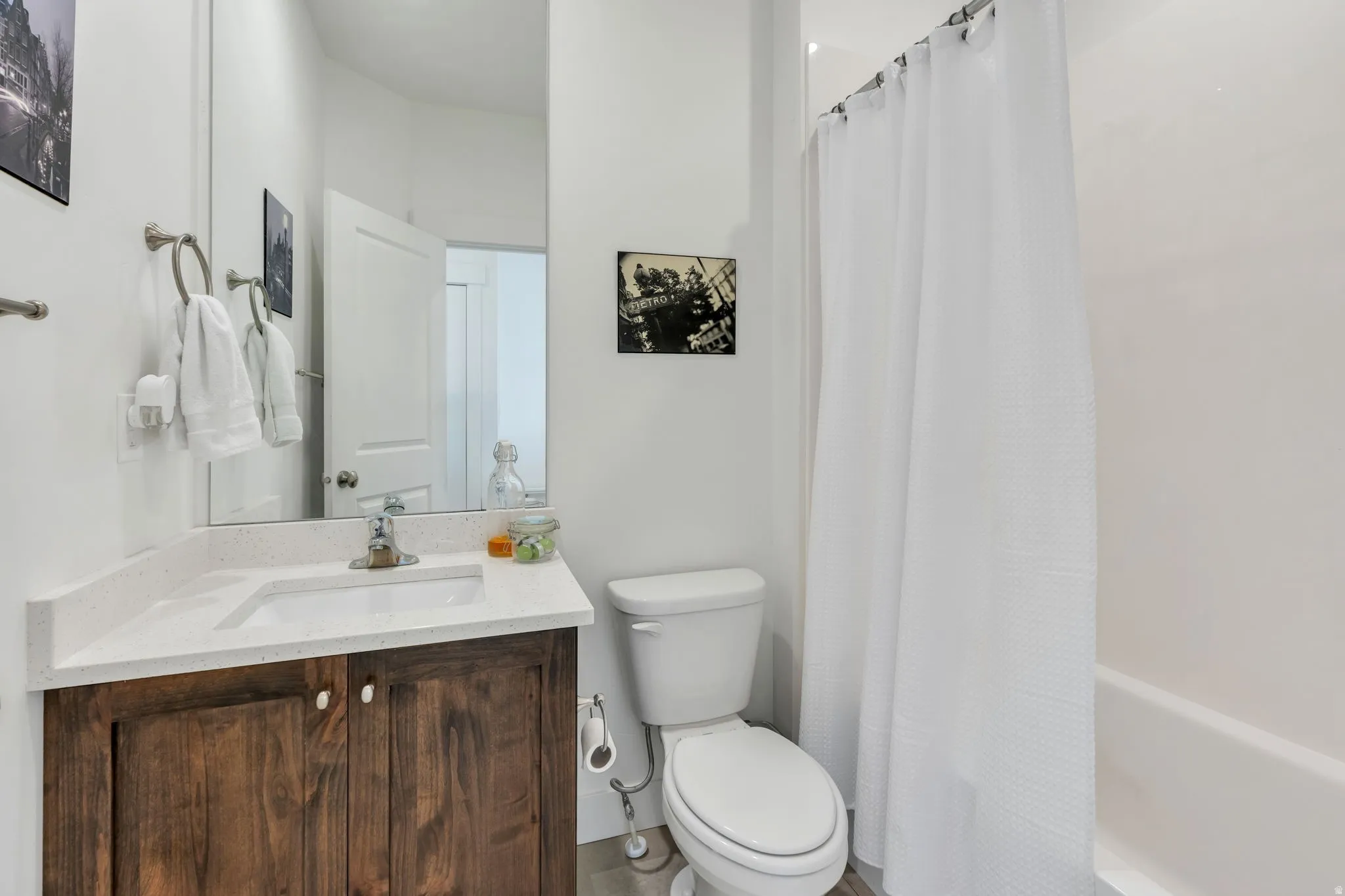 White-painted walls and a wood-finish vanity with a light-colored countertop