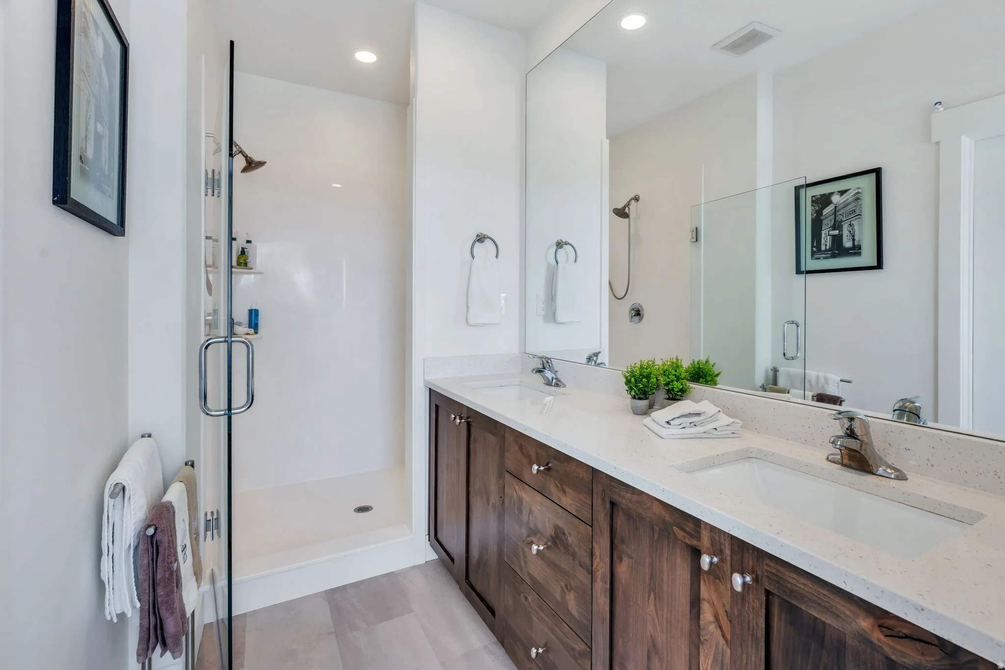 Dual sink vanity with dark wood-finish cabinetry, light-toned countertop, and undermount sinks