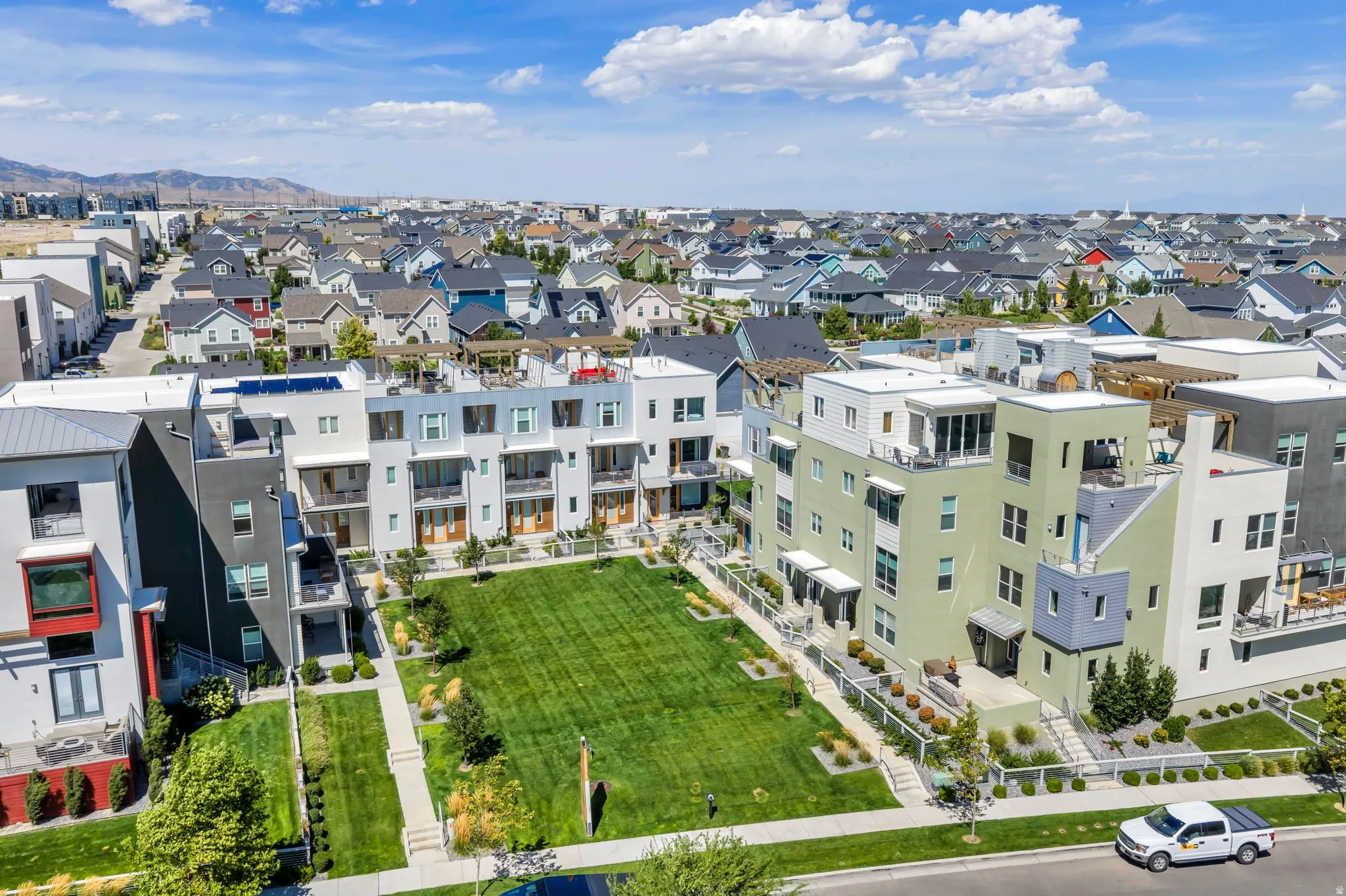 Modern multi-story residential buildings with balconies, flat roofs, and solar panels