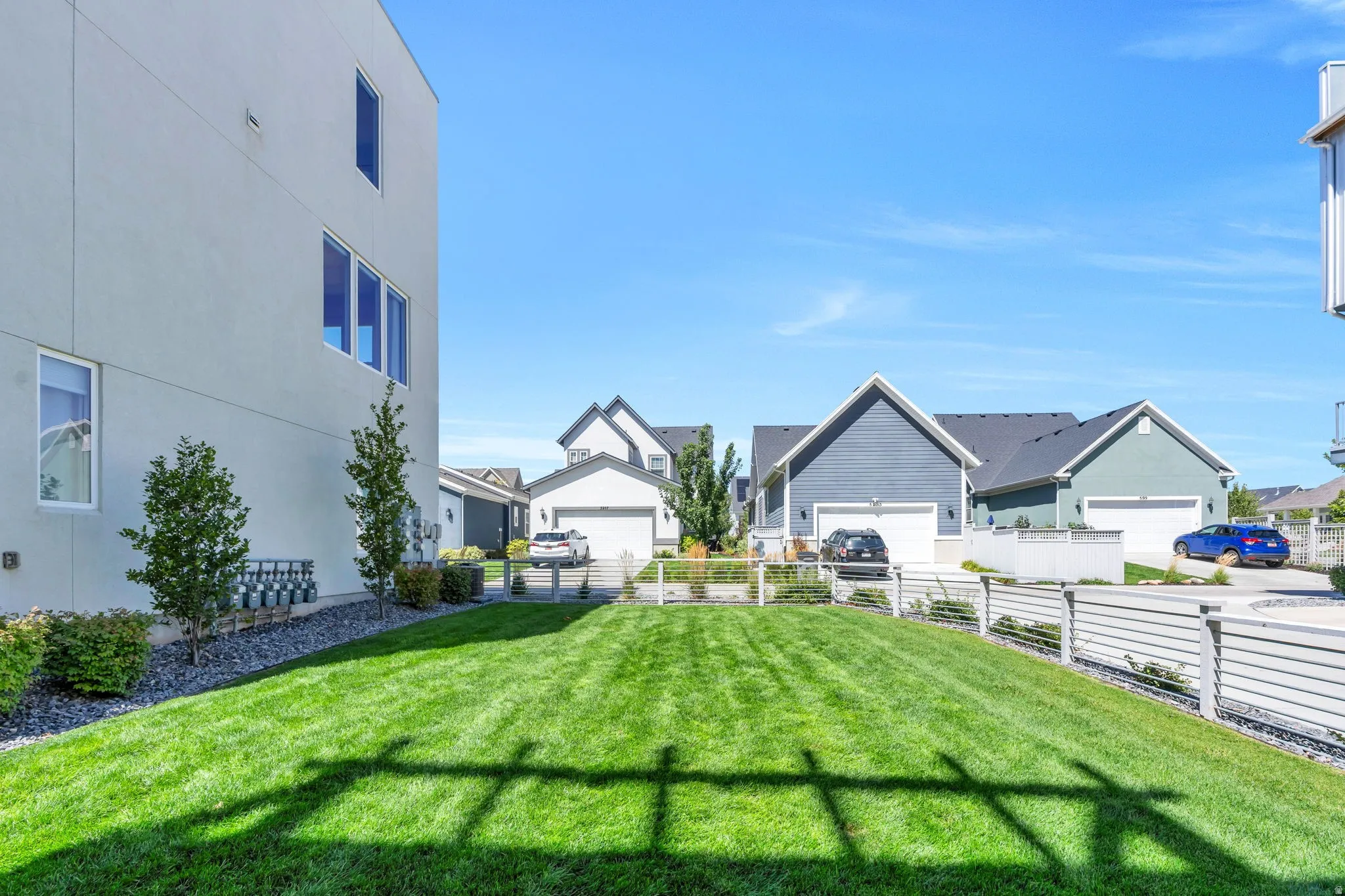 Expansive grass area with a modern horizontal slat fence