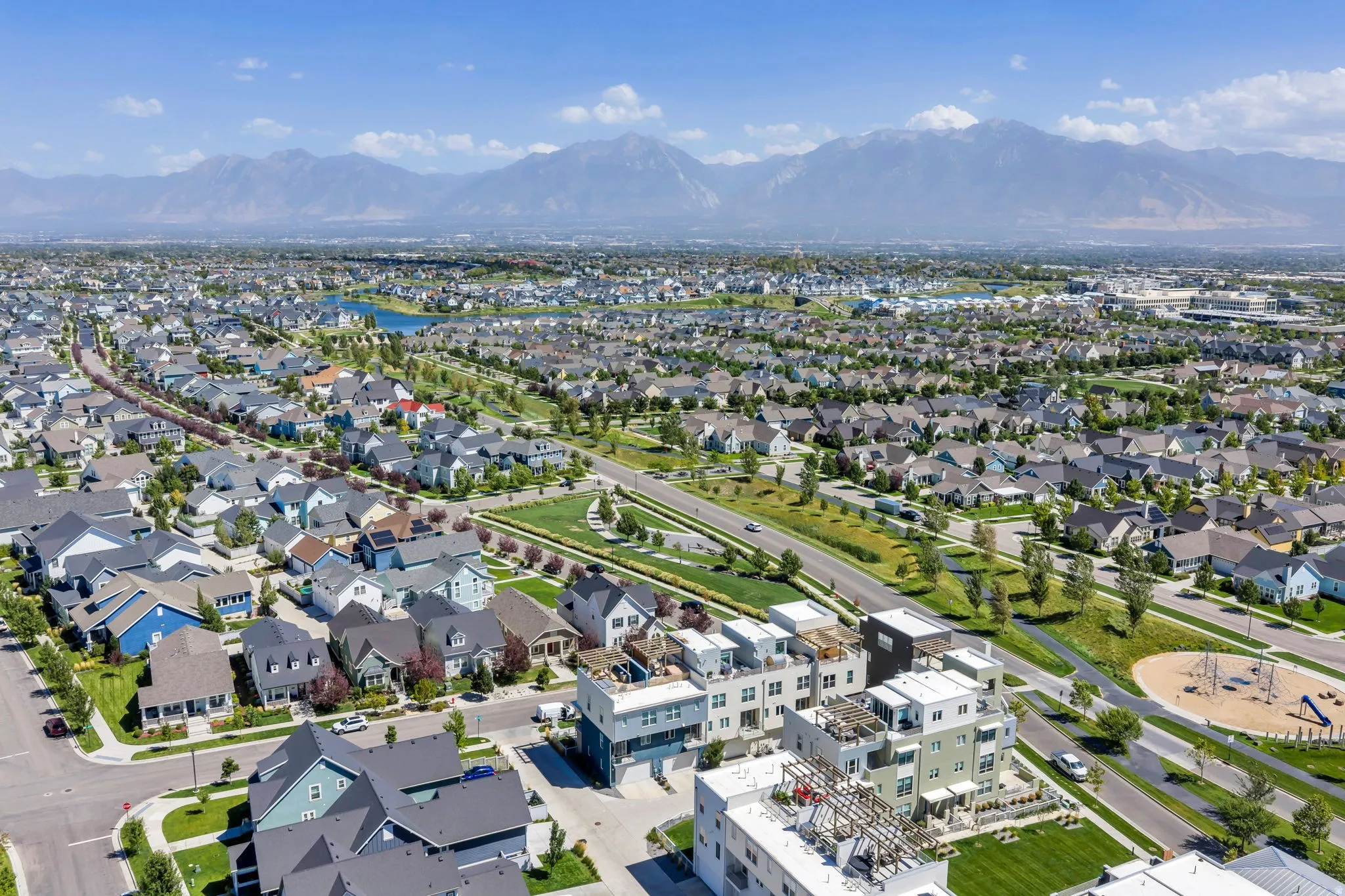 Expansive residential area featuring a diverse collection of homes, a large body of water, and distant mountains