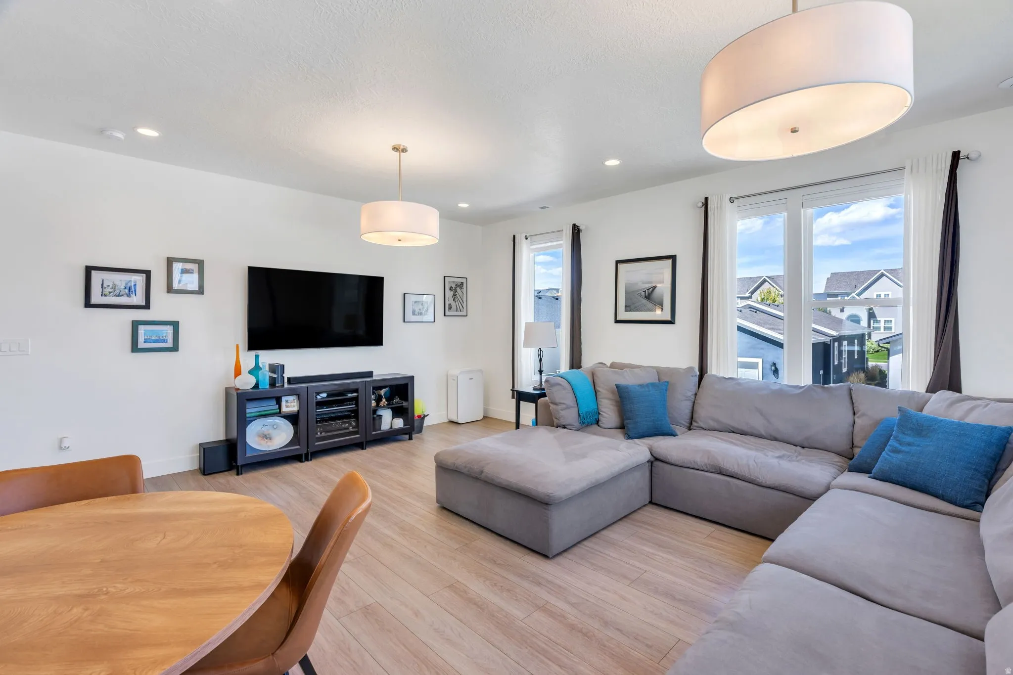 Wood-finish flooring, recessed lighting, and dual pendant light fixtures
