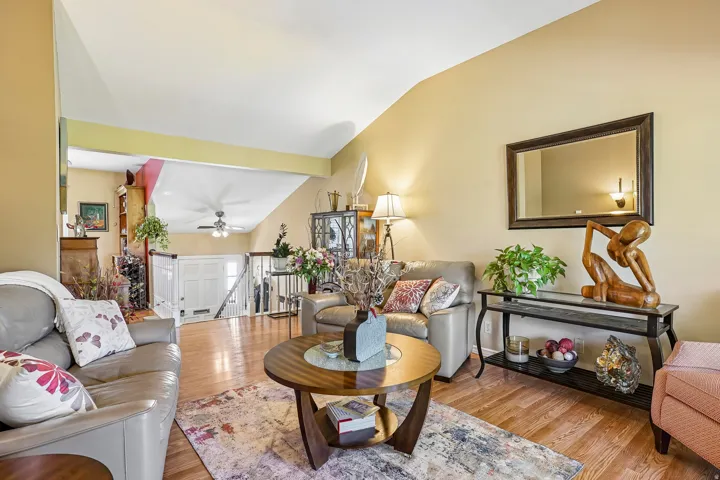 Vaulted ceiling, wood-finish flooring, half-wall partition, and an open concept layout