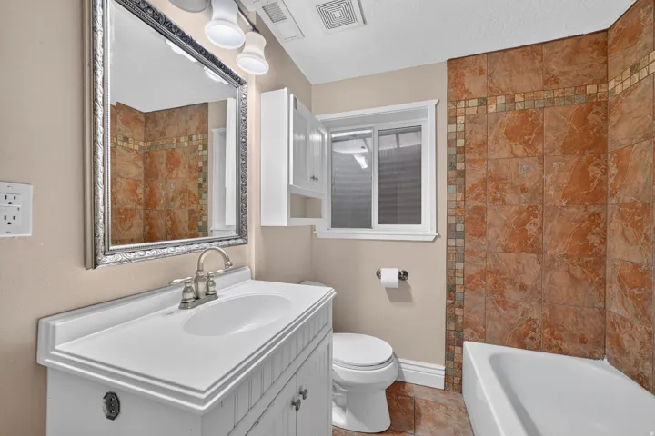 White vanity with beadboard paneling, brushed nickel faucet, and integrated sink