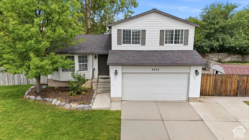 Two-story residence with white siding, an attached garage, a bay window, and a concrete driveway
