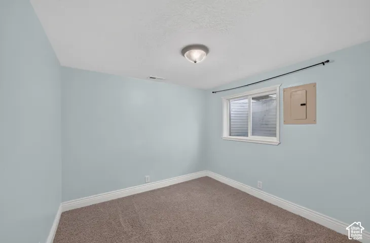 Recessed window with white trim, wall-mounted light fixture, and textured carpeting