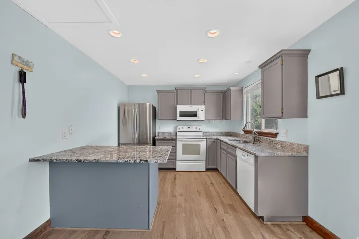 Kitchen featuring wood-finish flooring, recessed lighting, stone-finish countertops, and gray cabinetry