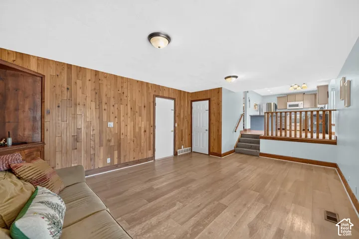 Wood-finish flooring throughout, complemented by a wood-paneled accent wall