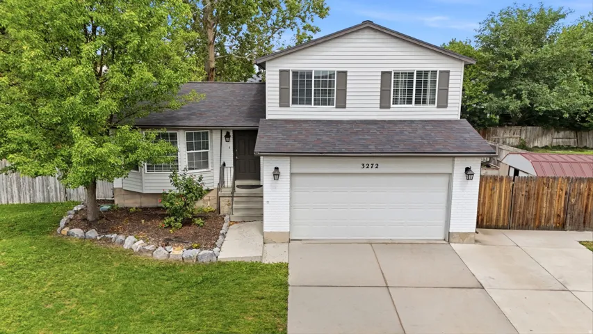 Two-story residence with white siding, an attached garage, a bay window, and a concrete driveway