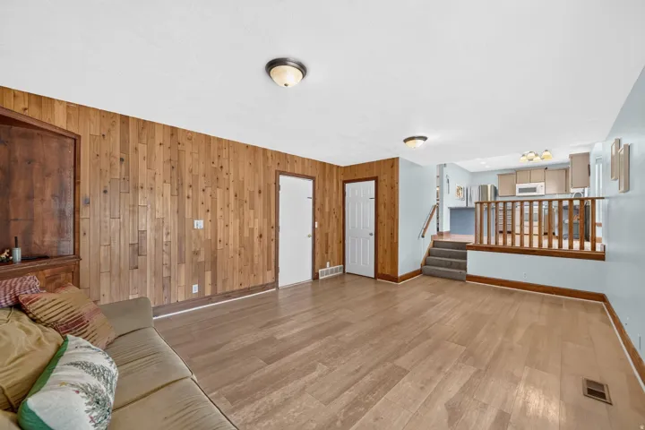 Wood-finish flooring throughout, complemented by a wood-paneled accent wall
